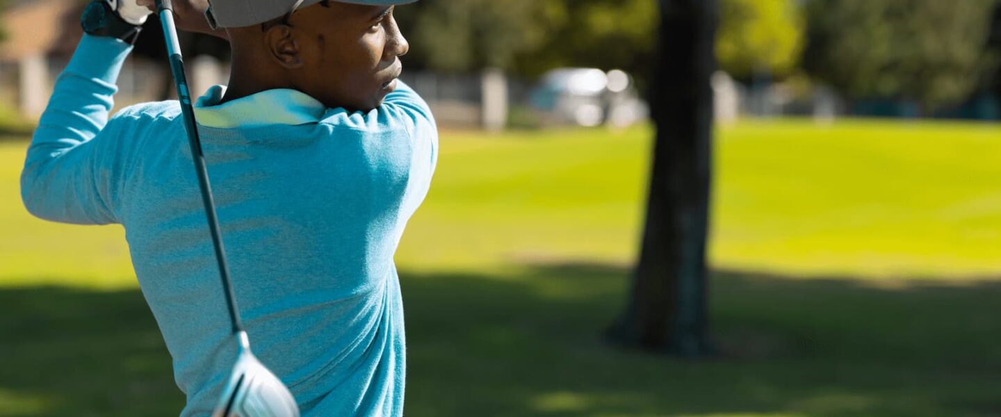 female golfer after a swing looking down fairway